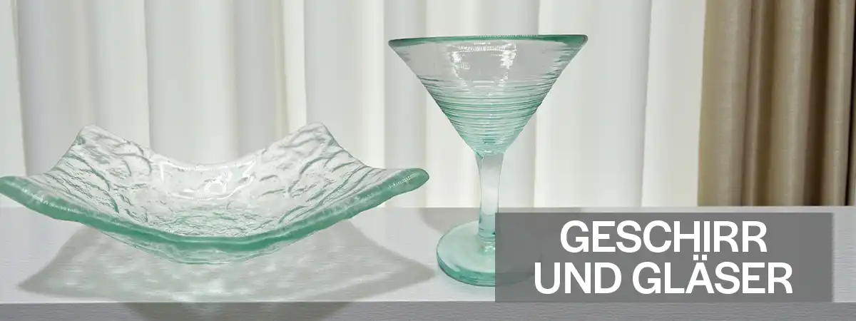 Hochwertiges Glasgeschirr, Trinkgläser und Karaffen auf einem massiven Esstisch