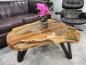 Preview: Baumstamm-Couchtisch mit Glasplatte und schwarzen Beinen.
