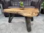 Preview: Couchtisch aus Baumstamm mit dunklen Holzmaserungen, Metallbeinen.