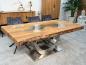 Preview: Esstisch aus recyceltem Altholz mit Edelstahlgestell und Glaseinlage.