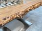 Preview: Massivholztisch aus recyceltem Altholz mit Baumstamm-Beinen.