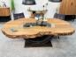 Preview: Massiver Holztisch mit Rohstahlgestell und Glasdetails.