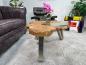 Preview: Tree trunk coffee table with glass top and metal legs in living room.