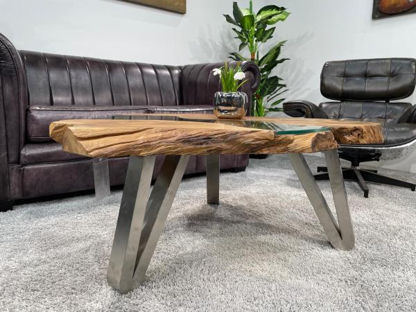 Tree trunk coffee table with glass top, irregular shape, wood finish.