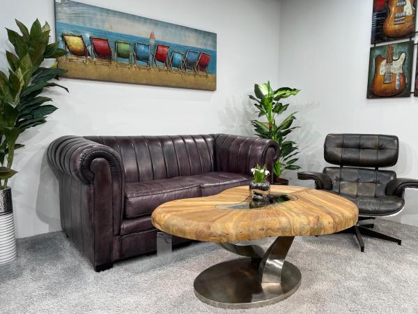 Coffee table with wooden top and stainless steel base on carpet