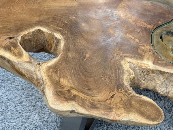 Teakholz-Couchtisch mit unregelmäßiger Oberfläche.