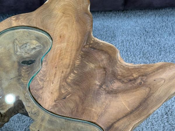 Couchtisch aus Teakholz mit unregelmäßiger Form und Glasplatte.
