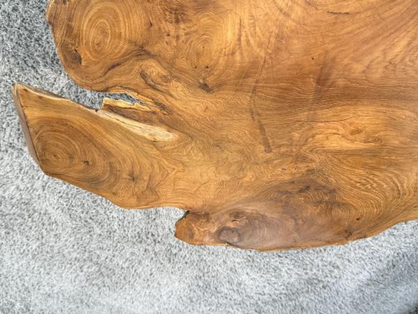 Detailansicht eines Teakholz-Couchtischs mit Metallbeinen.