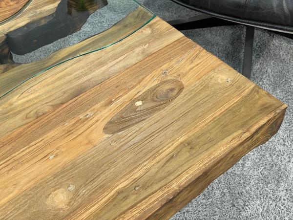 Wohnzimmertisch mit Holzplatte und gekreuztem Edelstahlgestell.