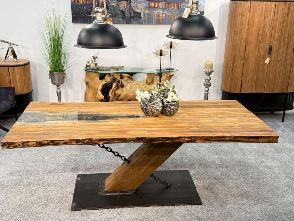 Esstisch aus Holz mit Metallkette und schrägem Bein.