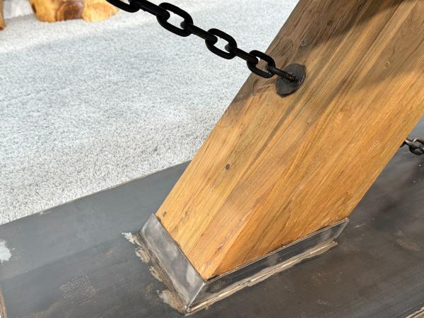 Detailansicht eines Tischbeins aus Holz mit Metallkette