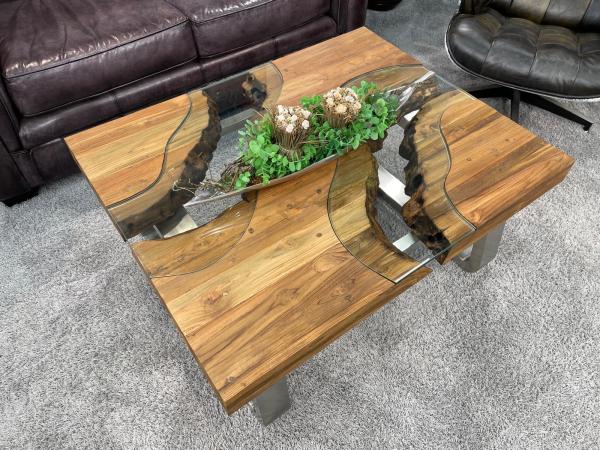 Eckiger Holztisch mit Glasplatte und Metallbeinen im Wohnzimmer.