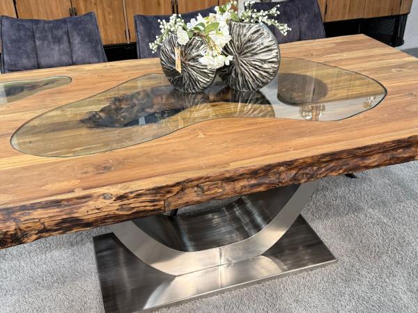 Esstisch aus recyceltem Altholz mit Edelstahlgestell und Glaseinlage.