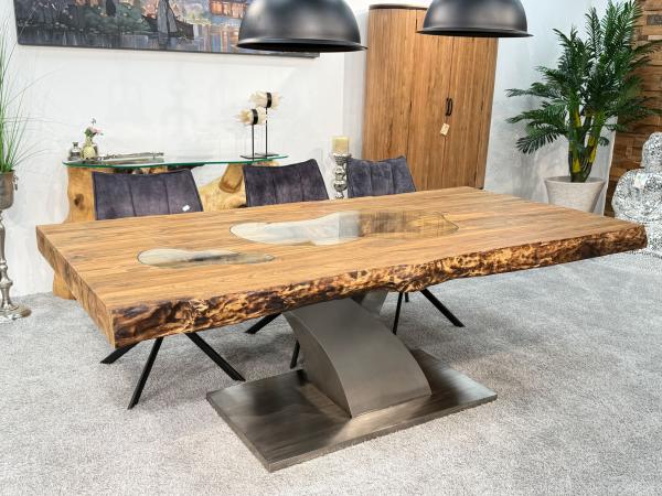 Massivholztisch aus recyceltem Altholz mit Baumstammbeinen.