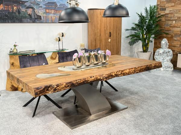 Massivholztisch aus recyceltem Altholz mit Baumstammbeinen.