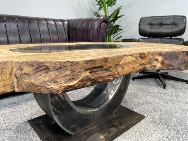 Organic wooden coffee table with oval shape and metal base.