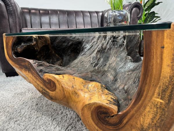 Nahaufnahme eines Wohnzimmertischs aus Suar-Holz mit Glasplatte.