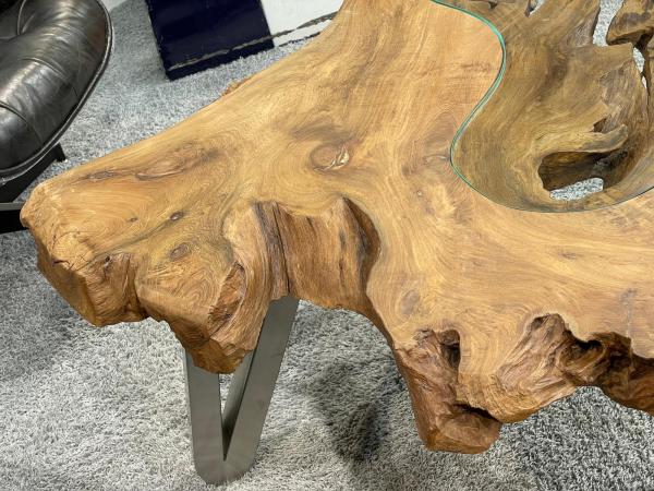 Wooden tree trunk coffee table with glass top, metal legs.