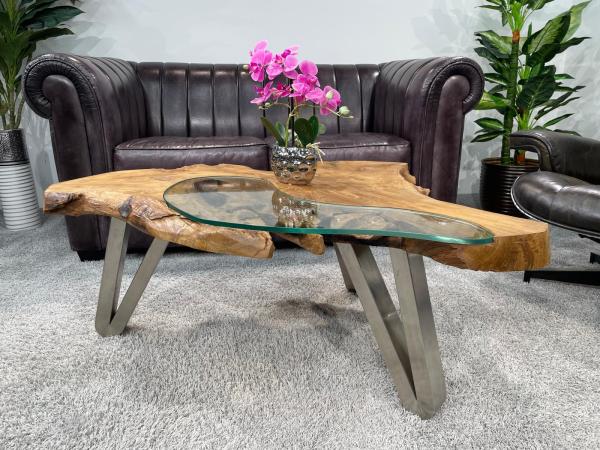 Log coffee table with glass top and metal legs in living room.