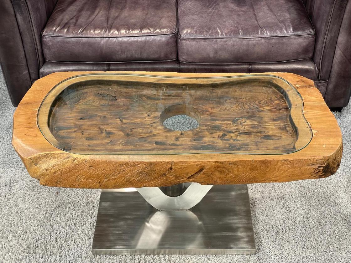 Coffee table from antique rice mortar with glass top, metal base.