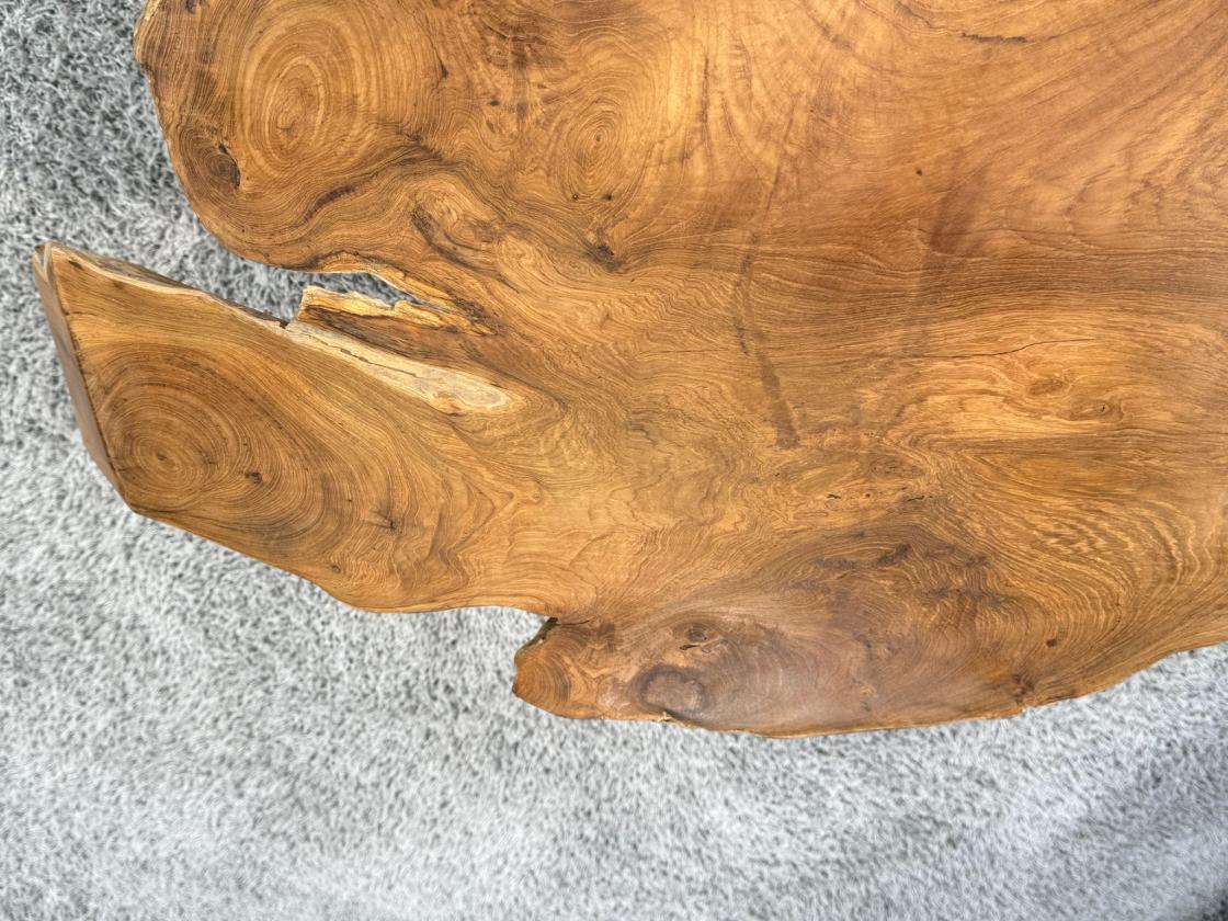 Detailansicht eines Teakholz-Couchtischs mit Metallbeinen.