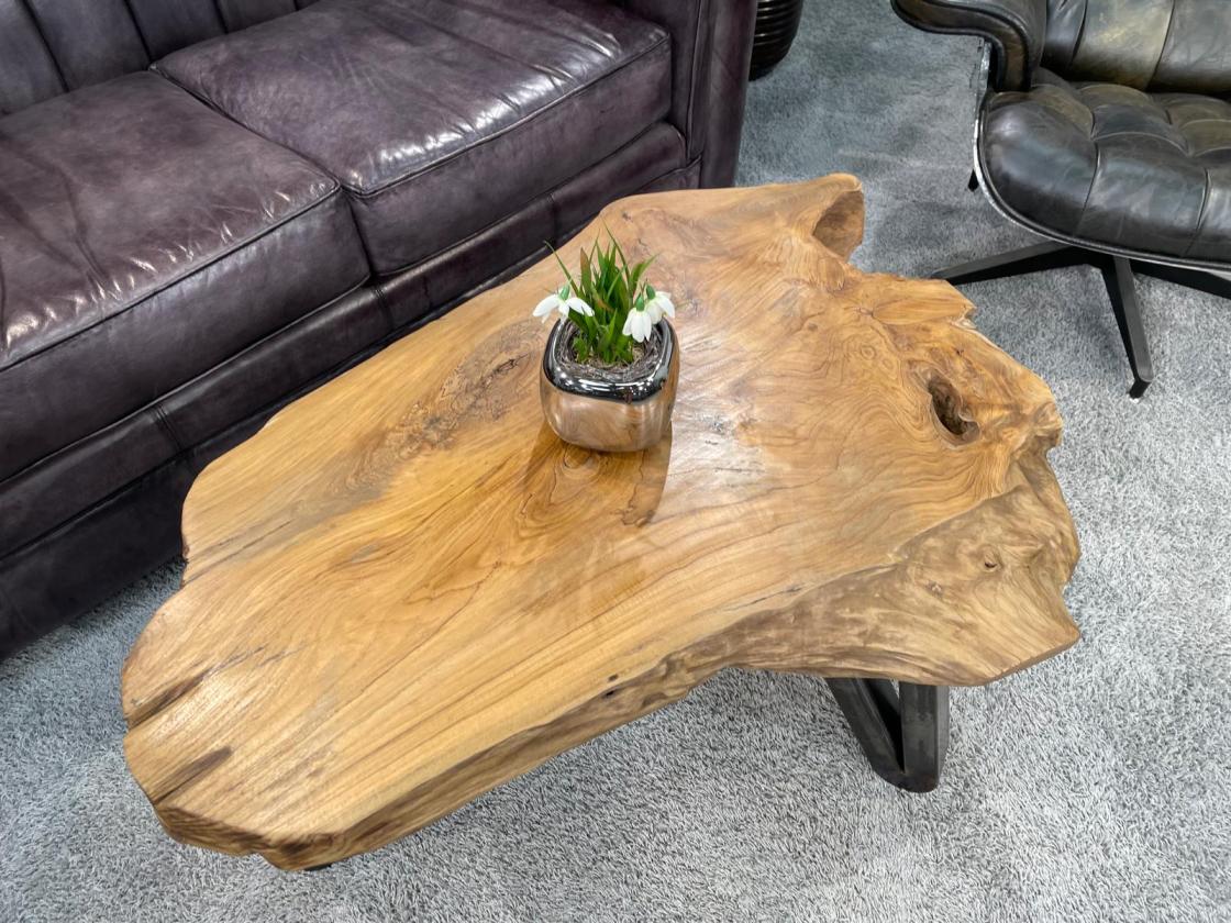 Couchtisch aus Baumstamm mit unregelmäßiger Form und Holzmaserung.