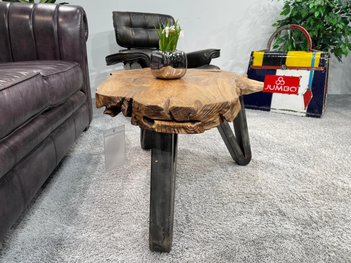 Couchtisch aus Baumstamm mit unregelmäßiger Form, Vase mit Blumen.