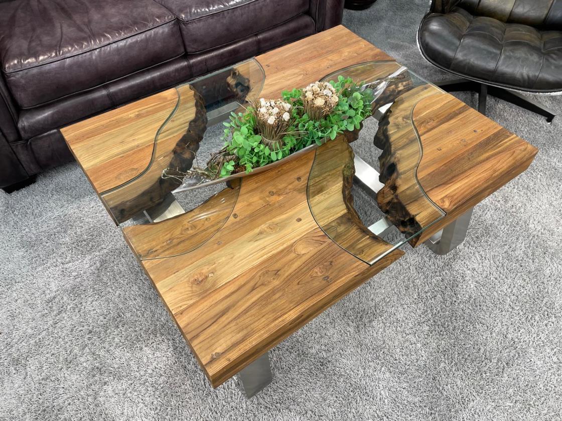 Eckiger Holztisch mit Glasplatte und Metallbeinen im Wohnzimmer.