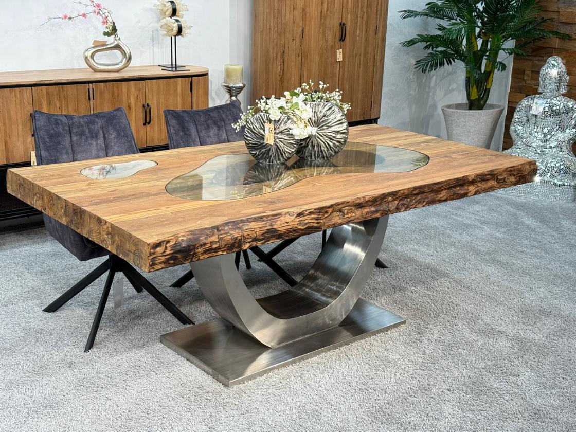 Esstisch aus recyceltem Altholz mit Edelstahlgestell und Glaseinlage.