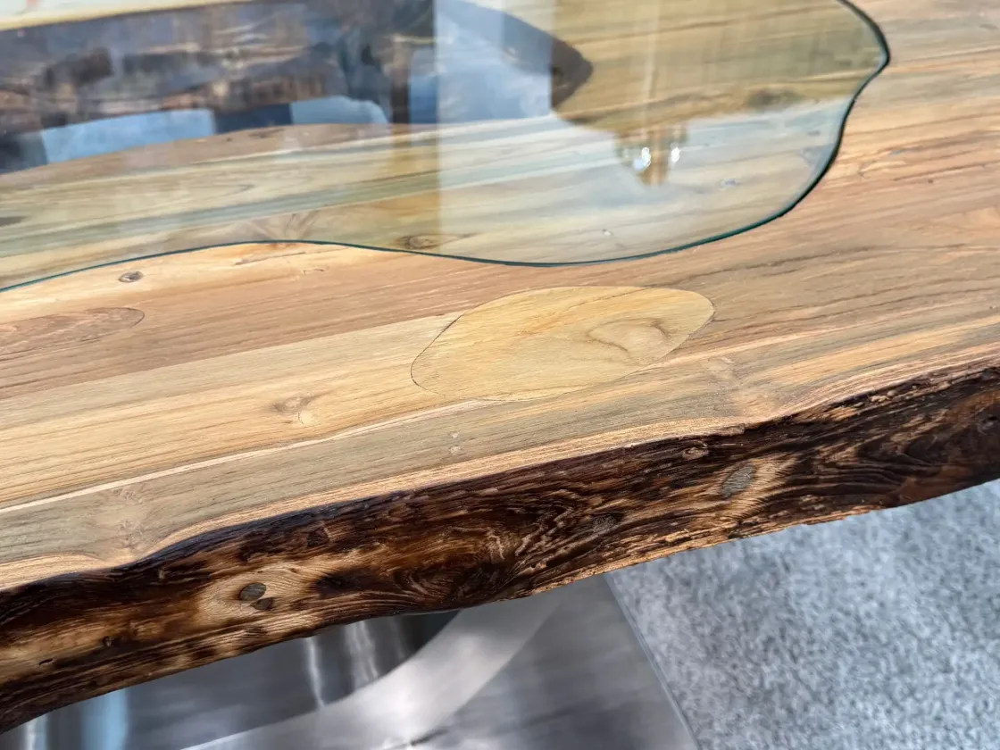 Solid wood dining table with glass inlays, close-up view.