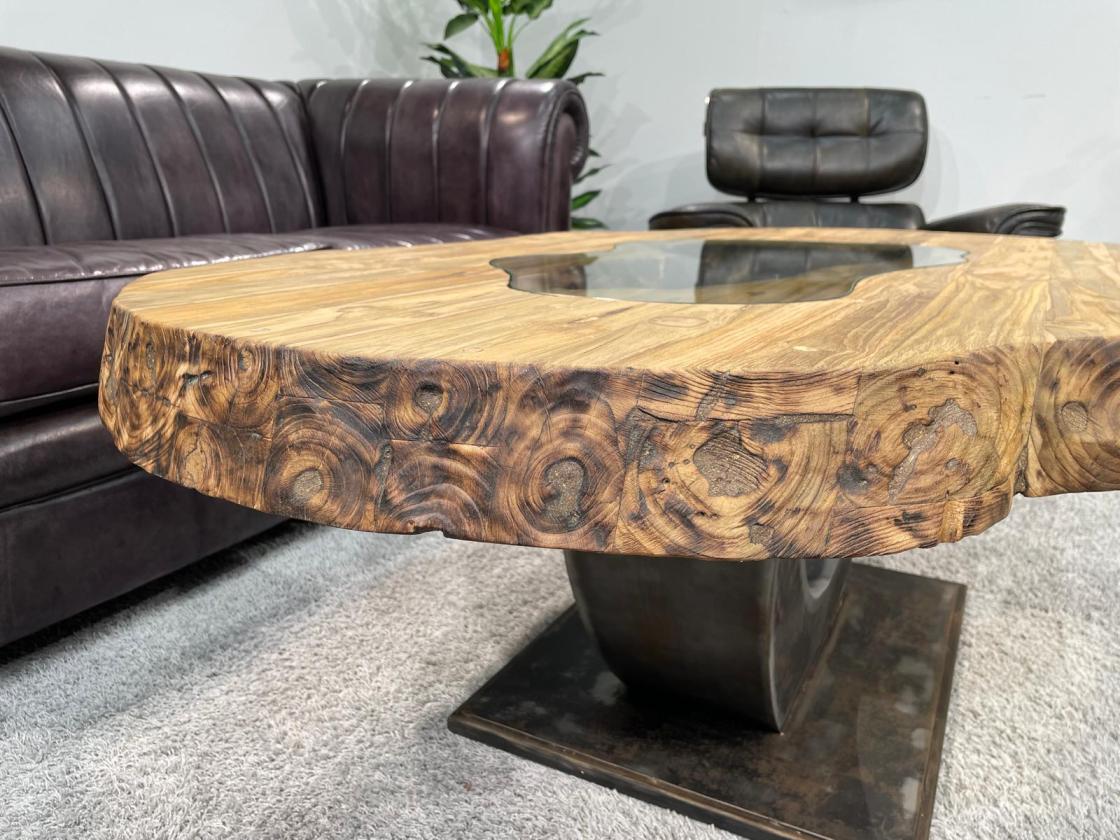 Oval wooden coffee table with glass top, metal base.