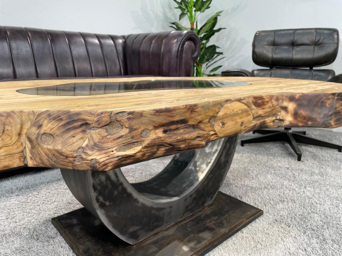 Organic wooden coffee table with oval shape and metal base.