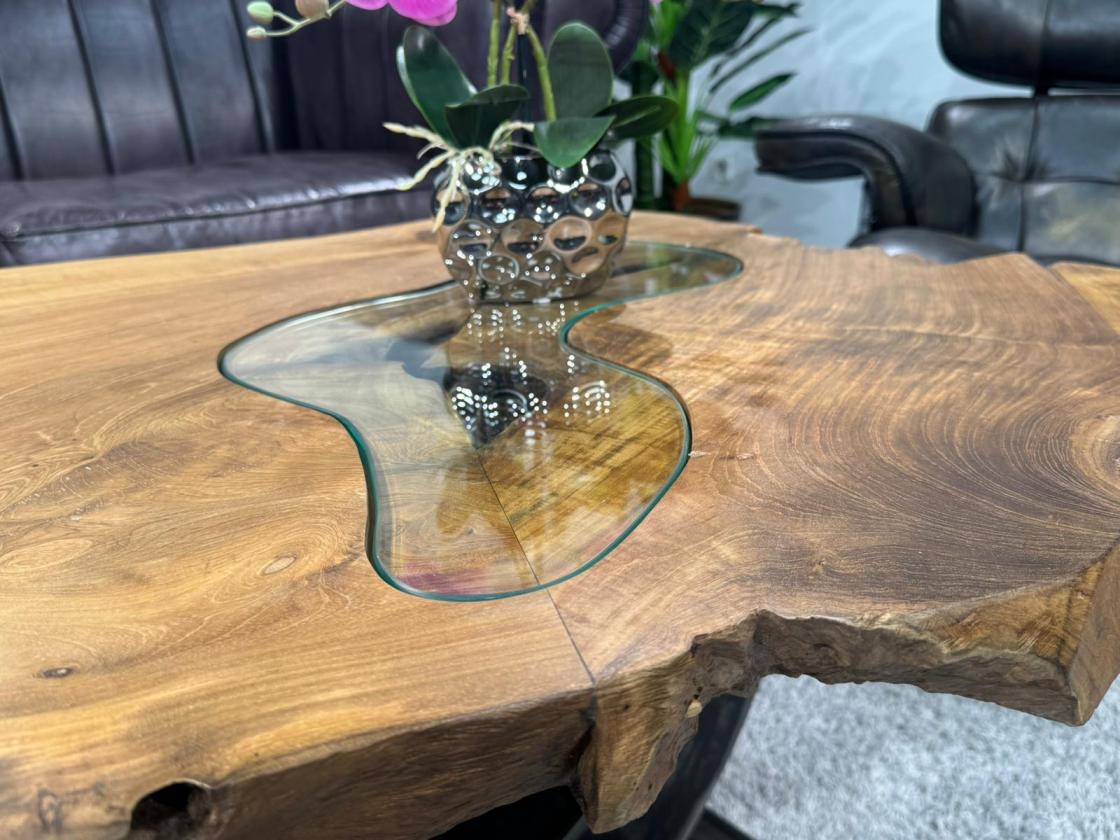 Coffee table made of solid wood with glass top, irregular shape.