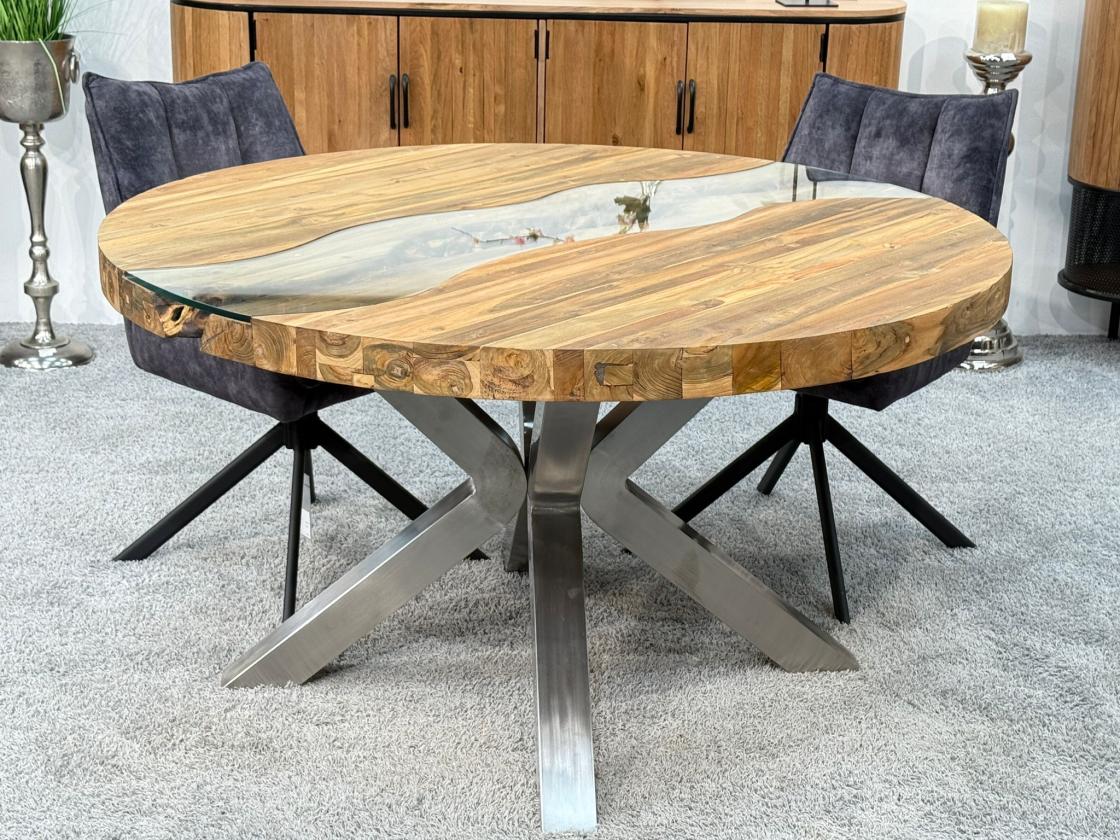 Round dining table made of recycled wood with glass insert and stainless steel frame.
