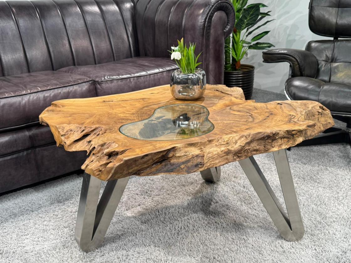 Log table with glass top, 90x75x45 cm, on carpeted floor.