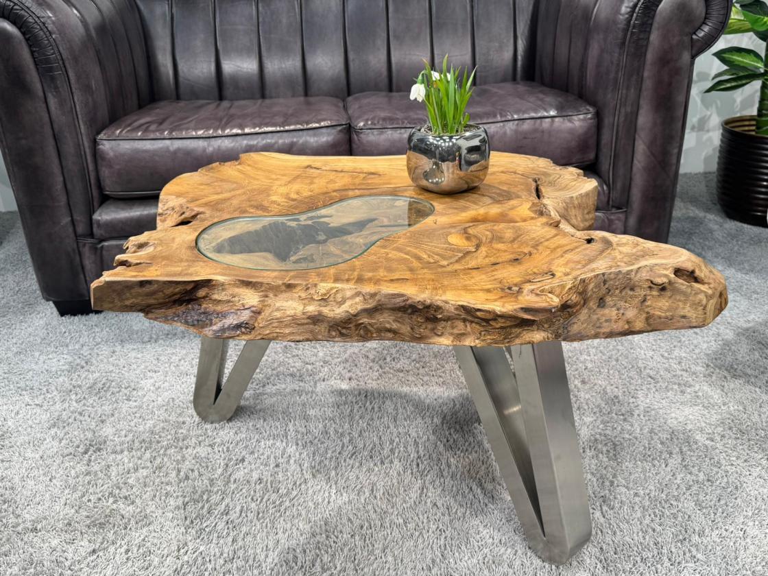 Log table with glass top and metal legs in living room.