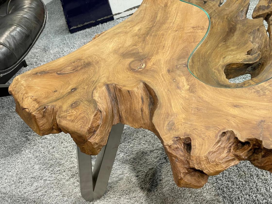 Wooden tree trunk coffee table with glass top, metal legs.