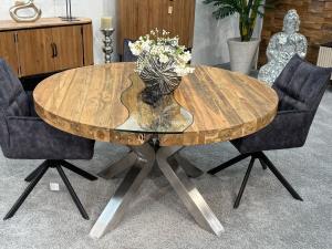 Round dining table made of recycled wood with stainless steel frame.